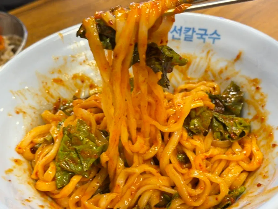 Eating bibim kalguksu alongside the octopus stir-fry