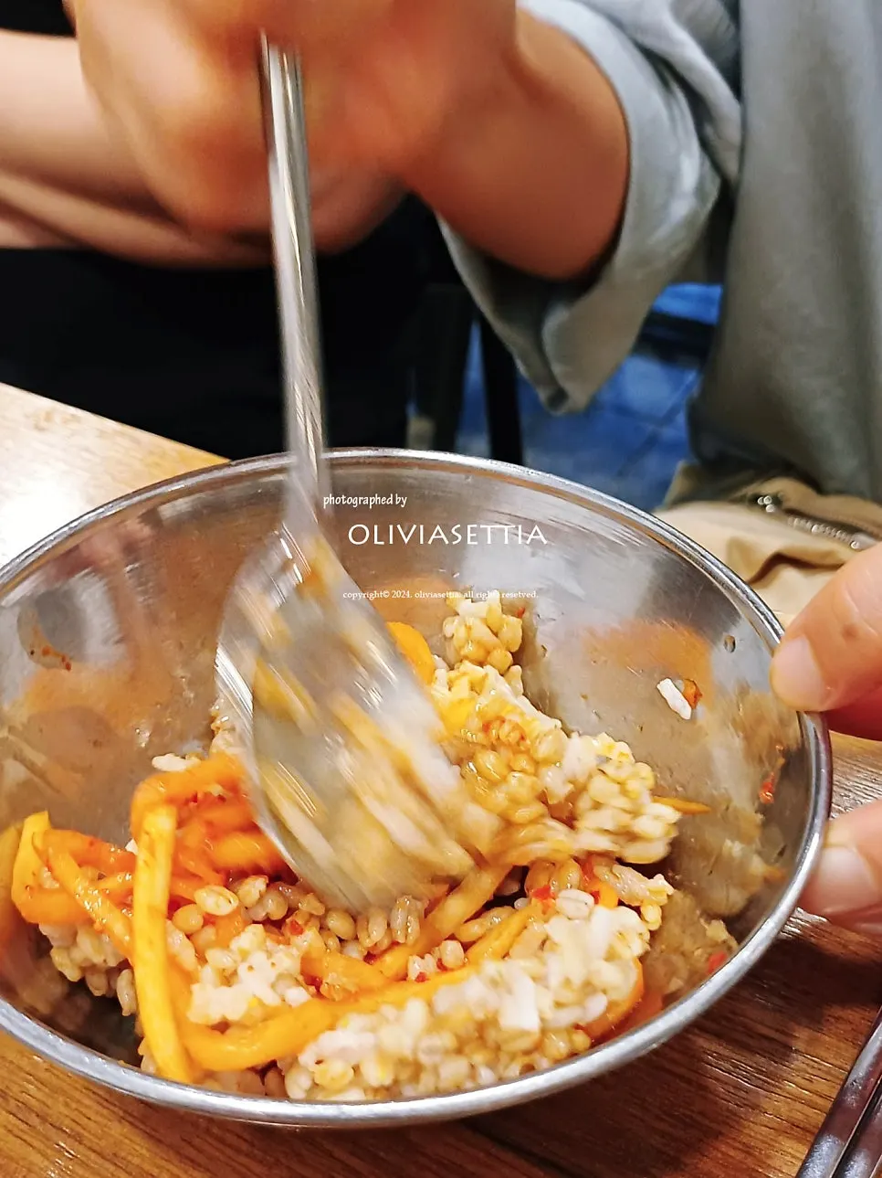 A bite of barley rice topped with bossam meat