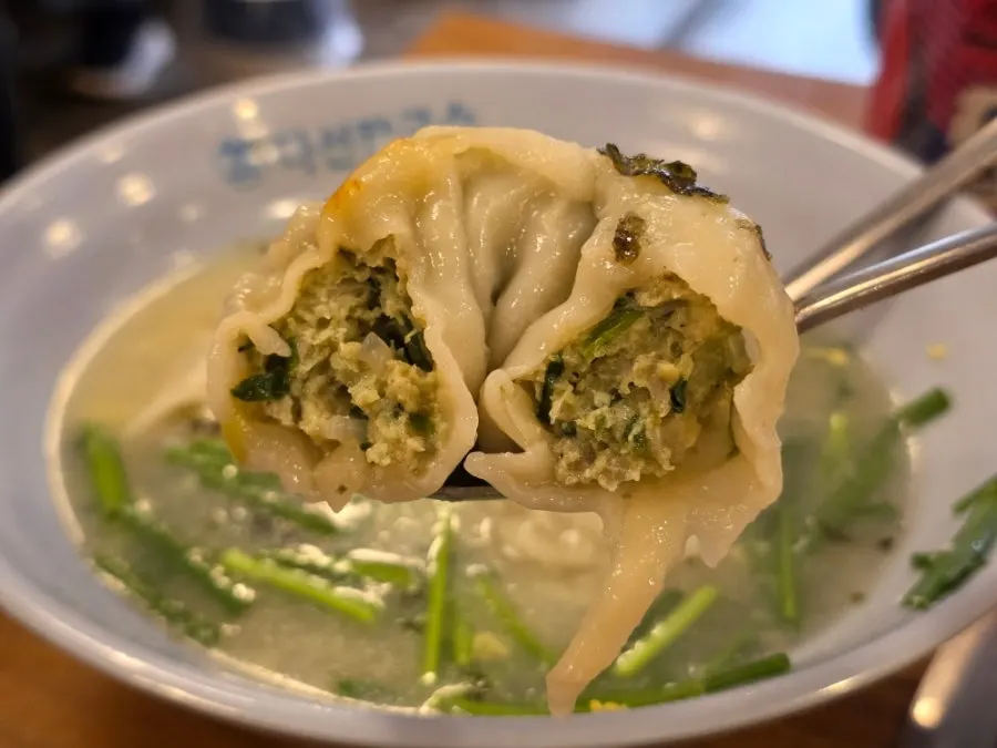 Picking up a dumpling from the mandu-guk