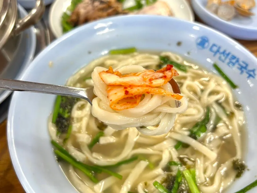칼국수에 겉절이 김치를 올린 한 젓가락
