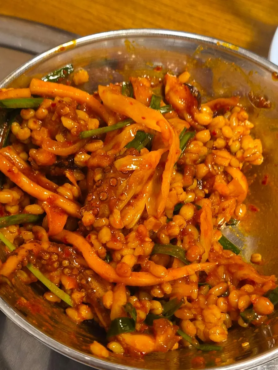 A bite of octopus and vegetables lifted together