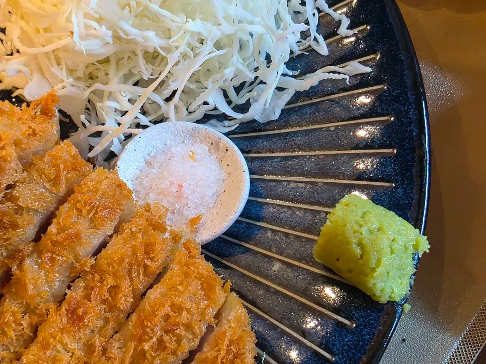 A piece of rosu katsu dipped in salt