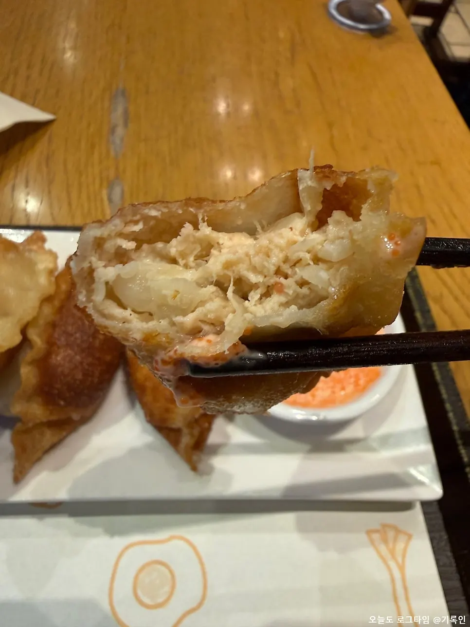 A mentaiko gyoza dipped in tobiko sauce