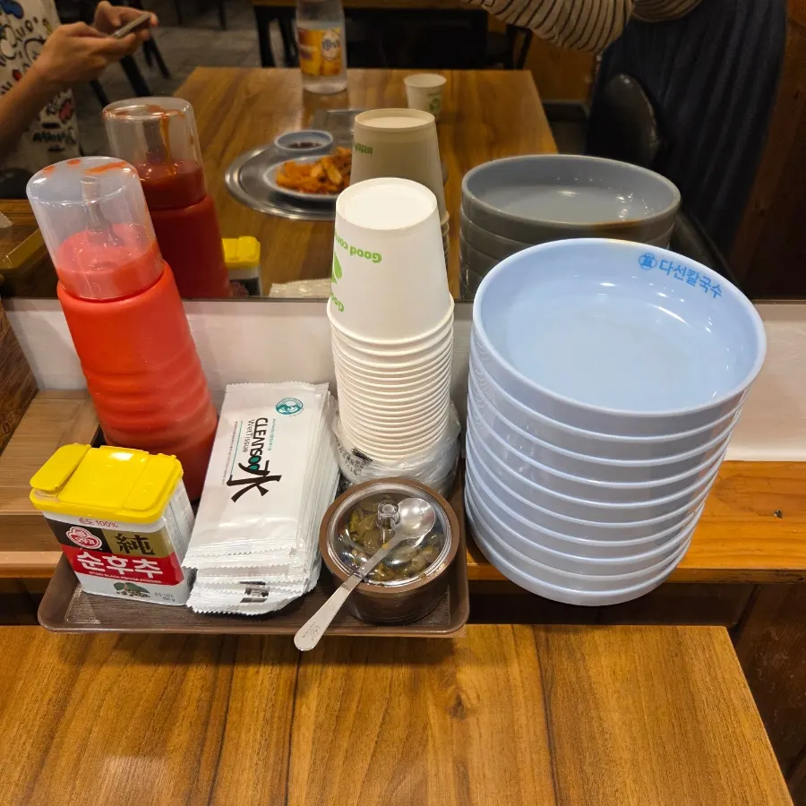 Pepper, chojang sauce, cups and plates set on the table