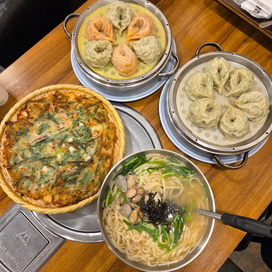 Table spread with kalguksu set meal, dumplings and seafood pajeon