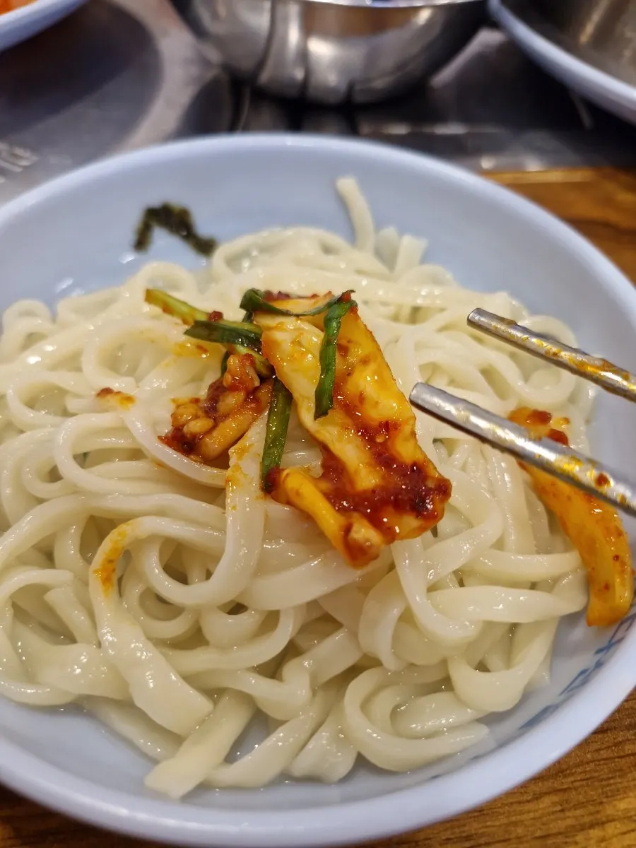 칼국수에 겉절이를 올린 한 젓가락