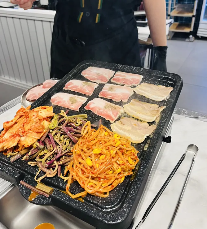Staff grilling the first batch on the grill pan