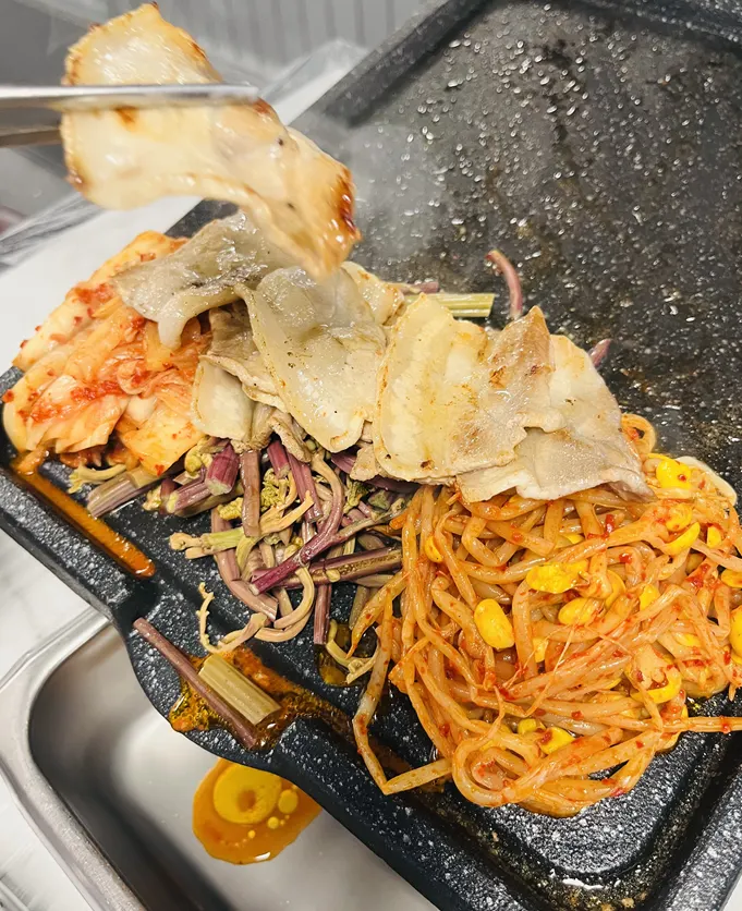 Pork belly grilling together with fernbrake, bean sprouts, and cabbage kimchi