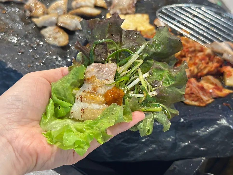 A bite of pork belly enjoyed in a lettuce wrap