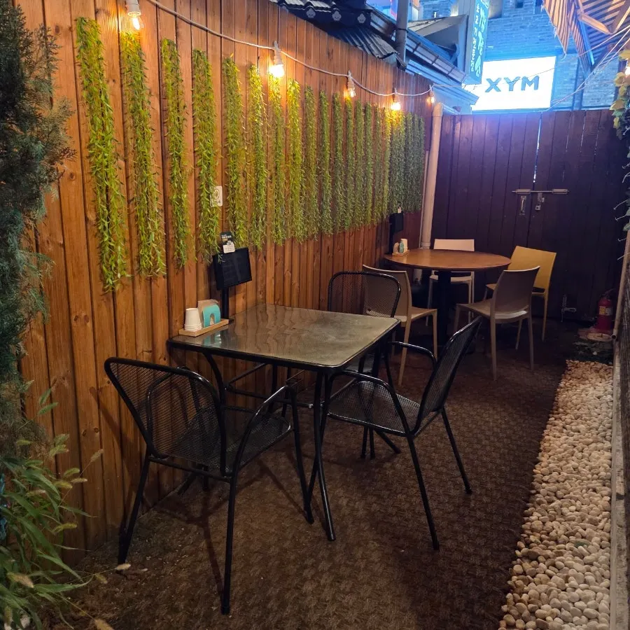 Outdoor seating at Paldal Jutaek lit with string lights