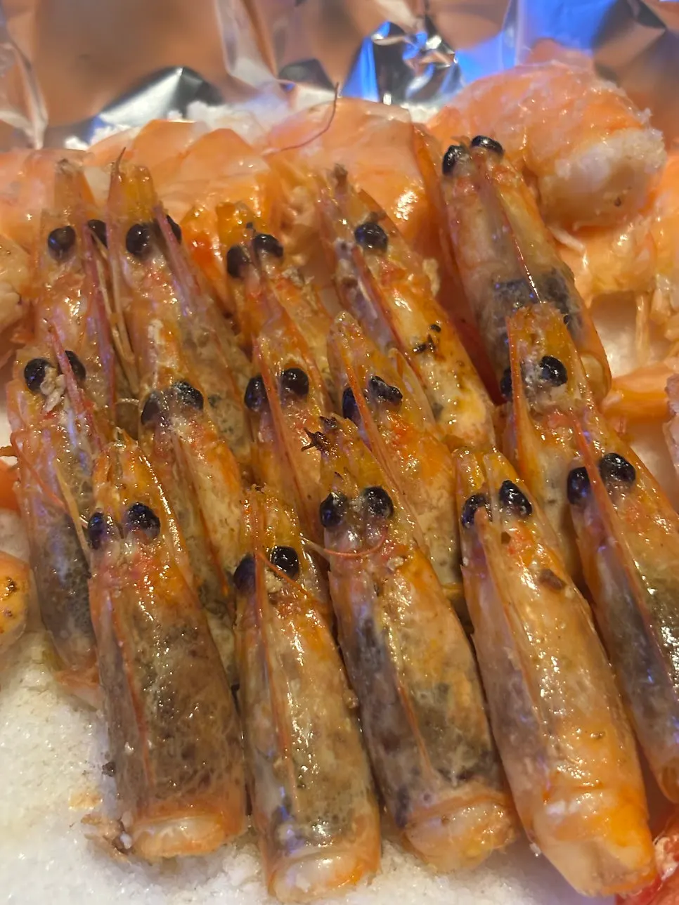 Plump grilled tiger prawns served on coarse salt