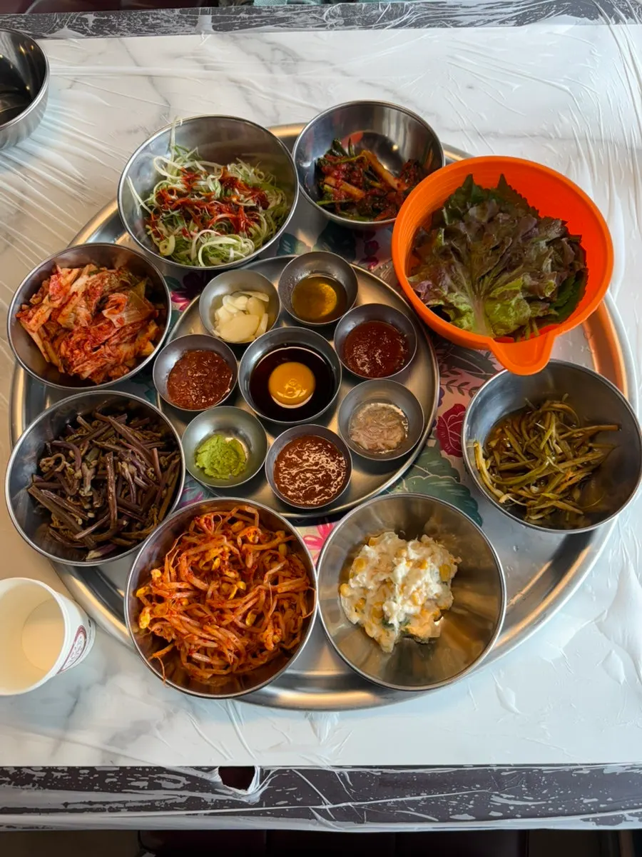Table setting with sliced scallions, bean sprouts, bracken, and kimchi