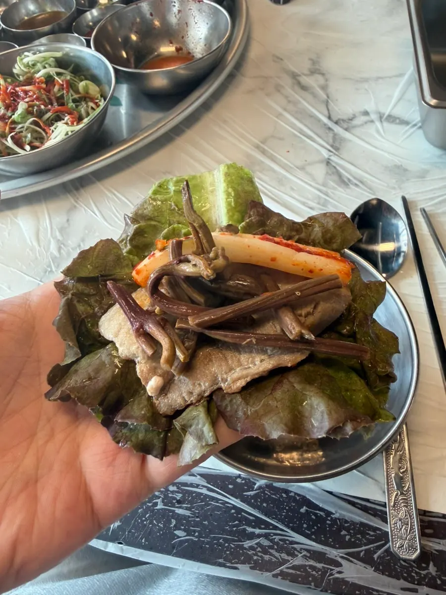 A piece of meat with grilled kimchi on a small plate