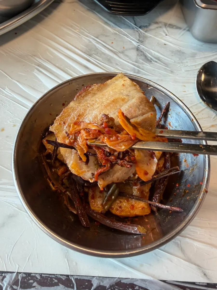 Meat and sliced scallions piled on a small plate