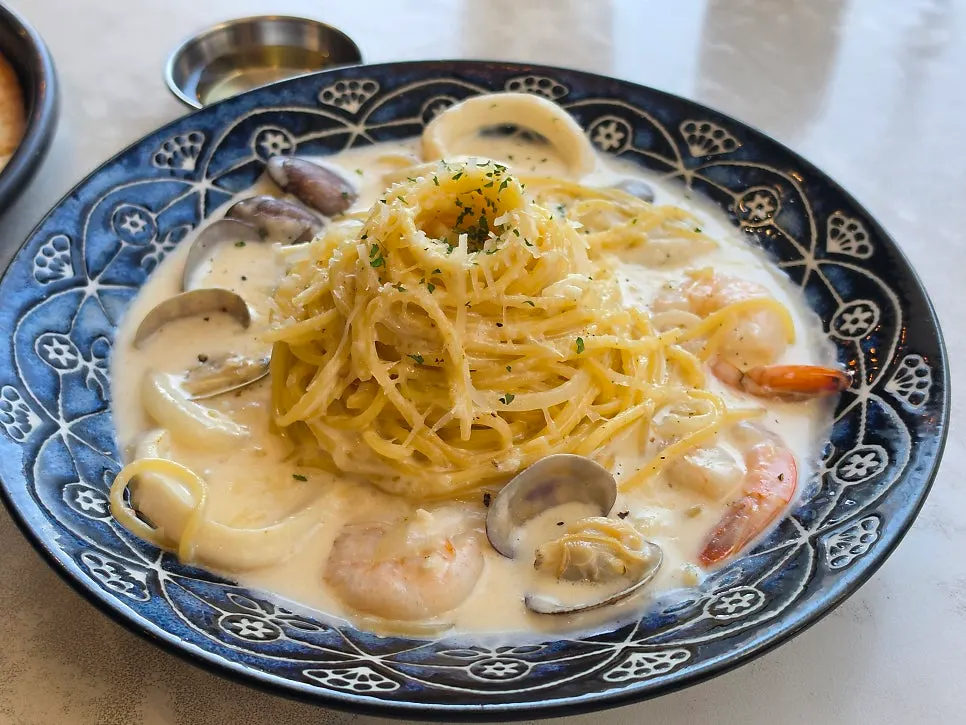 A plate of Rolling Pasta's seafood cream pasta