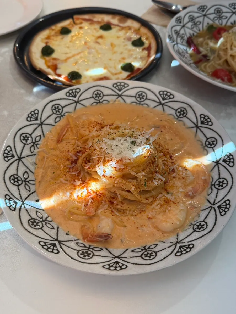 A plate of rosé cream shrimp pasta topped with shrimp