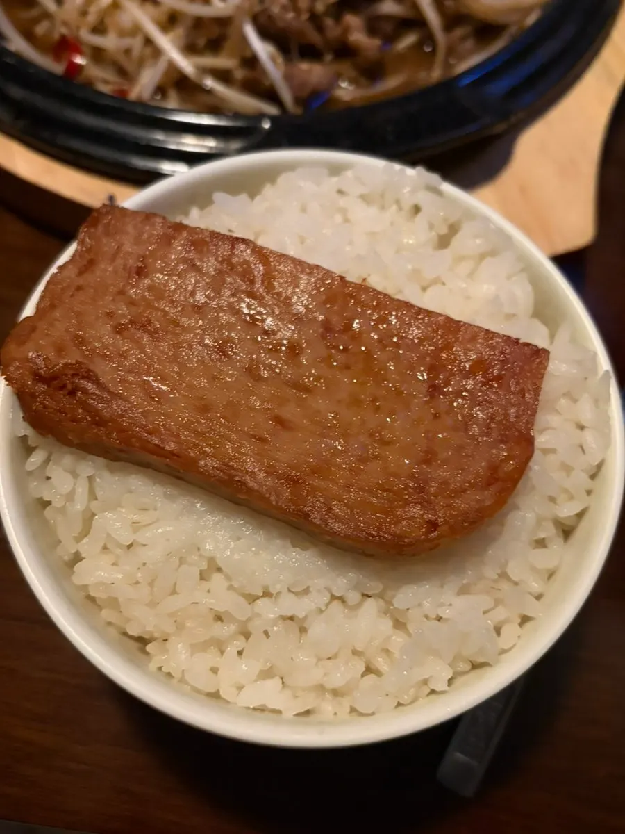 A bowl of rice topped with a slice of Spam