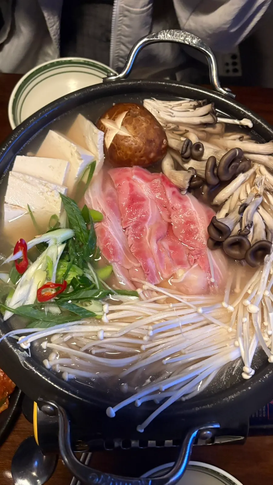 선홍빛 우삼겹이 올려진 전골 상차림