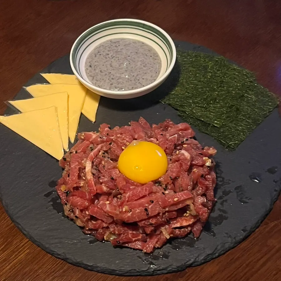 Manseok yukhoe served with cheese, black sesame sauce, and gamtae