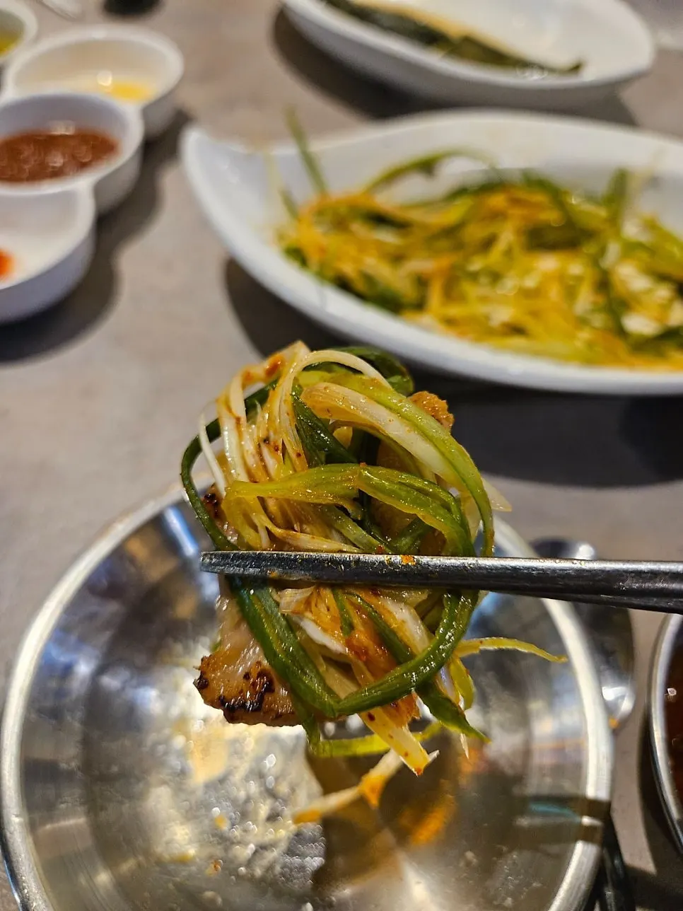 파절이를 듬뿍 올린 삼겹살 한 점
