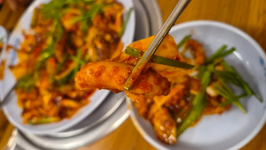 Picking up a piece of octopus from the stir-fry