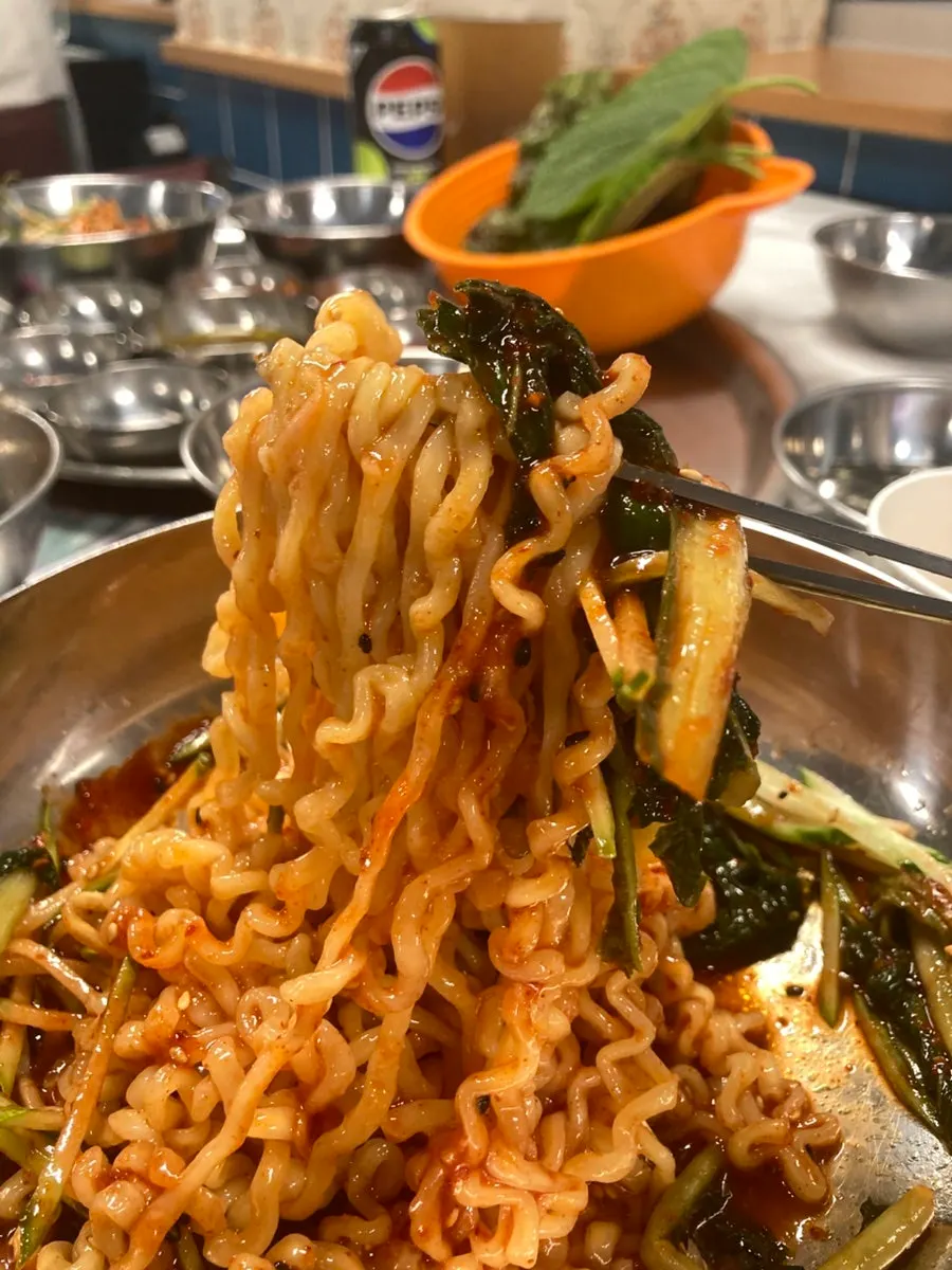 Taejang bibim noodles served alongside the frozen pork belly