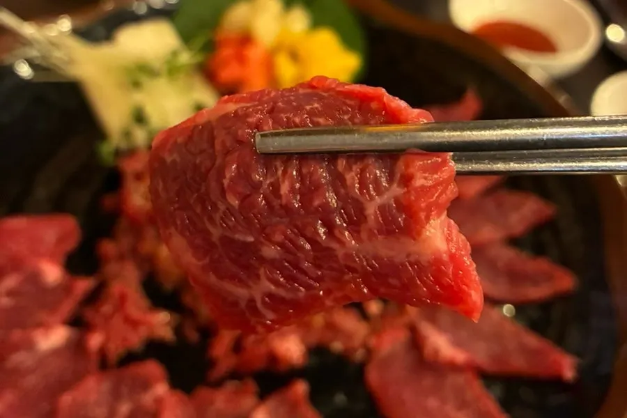 A bite of yukhoe mixed with egg yolk