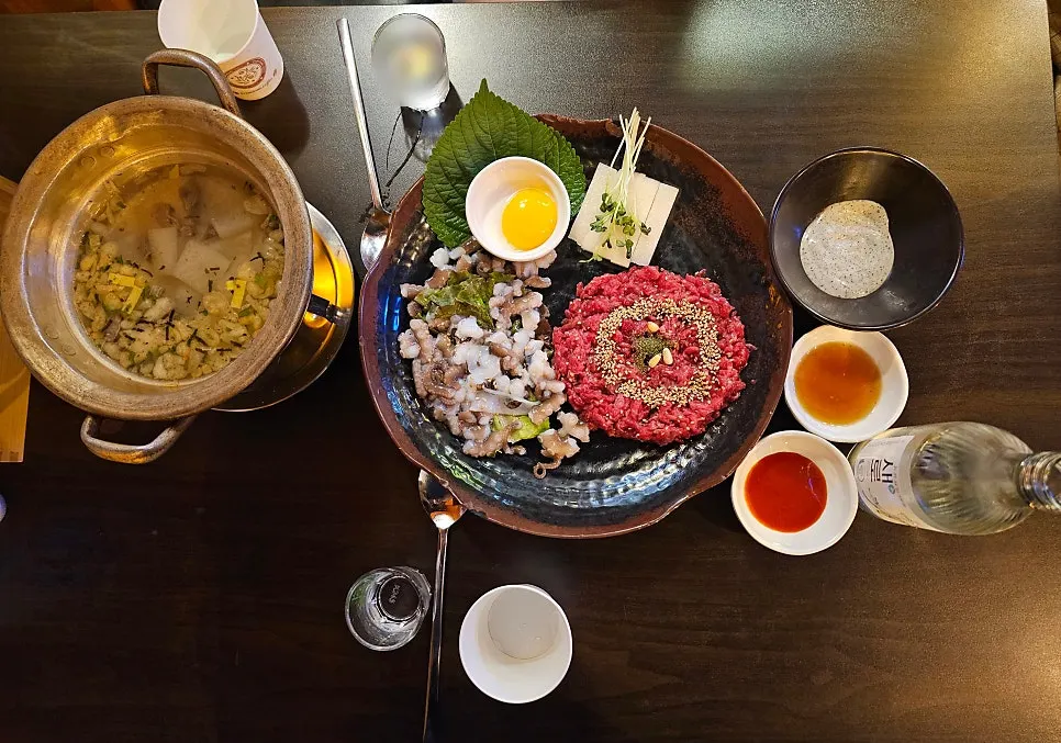 Table set with live octopus hanwoo yukhoe and soju