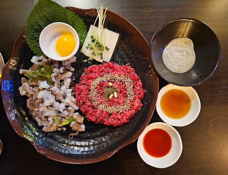 Live octopus hanwoo yukhoe served on a plate