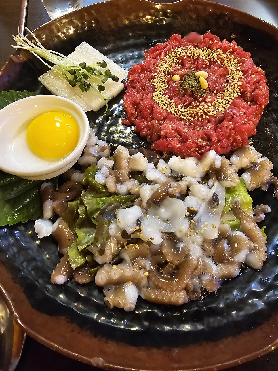 Live octopus placed beside Korean beef yukhoe