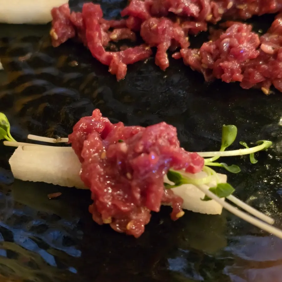 Tartare topped with a plump egg yolk