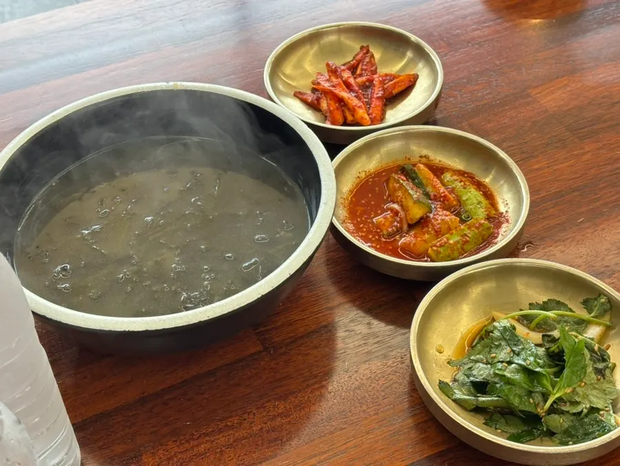 Plates of japchae and seasoned greens among the side dishes