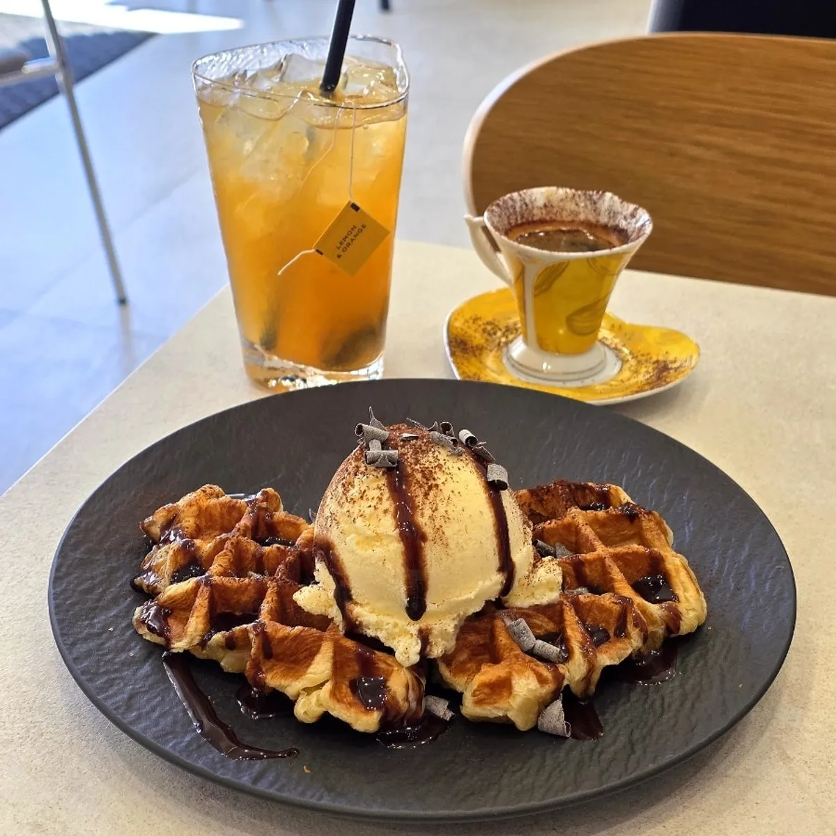 Roma espresso, peach iced tea, and chocolate croffle laid out together