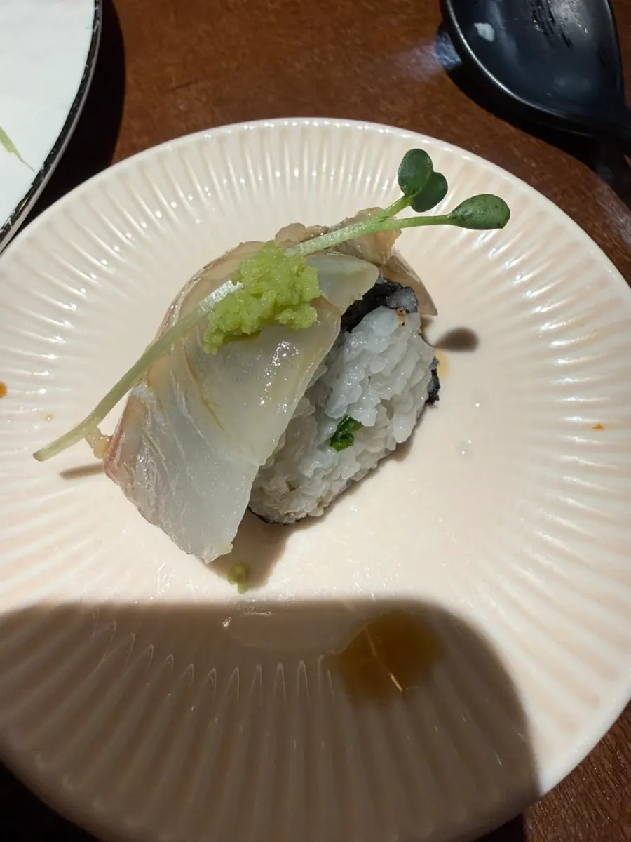 A piece of flounder sashimi with wasabi