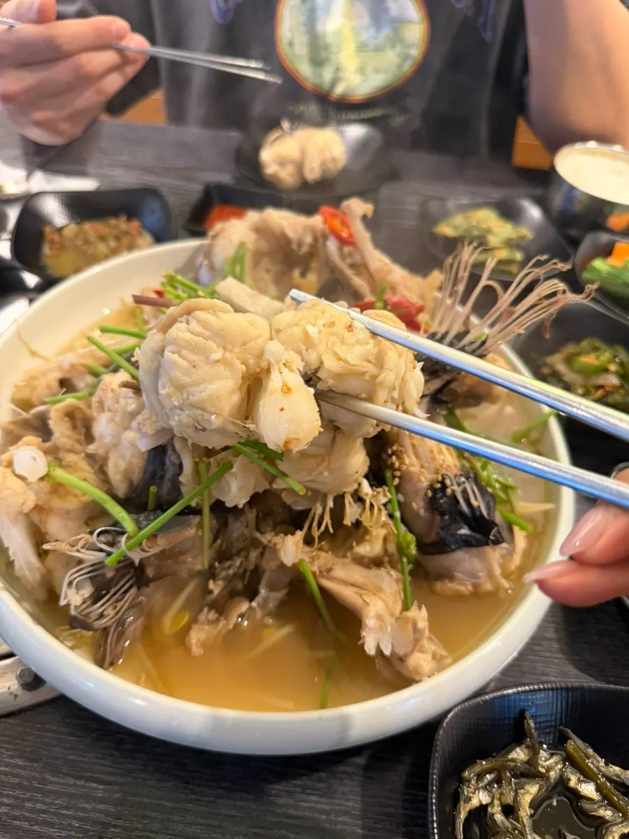 A piece of agu suyuk dipped in broth