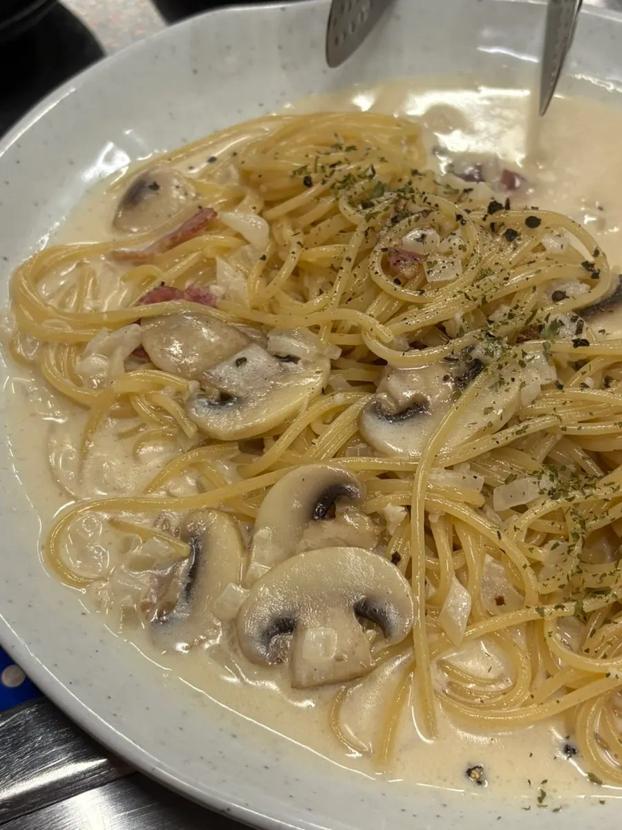 A plate of cream pasta with plenty of sauce