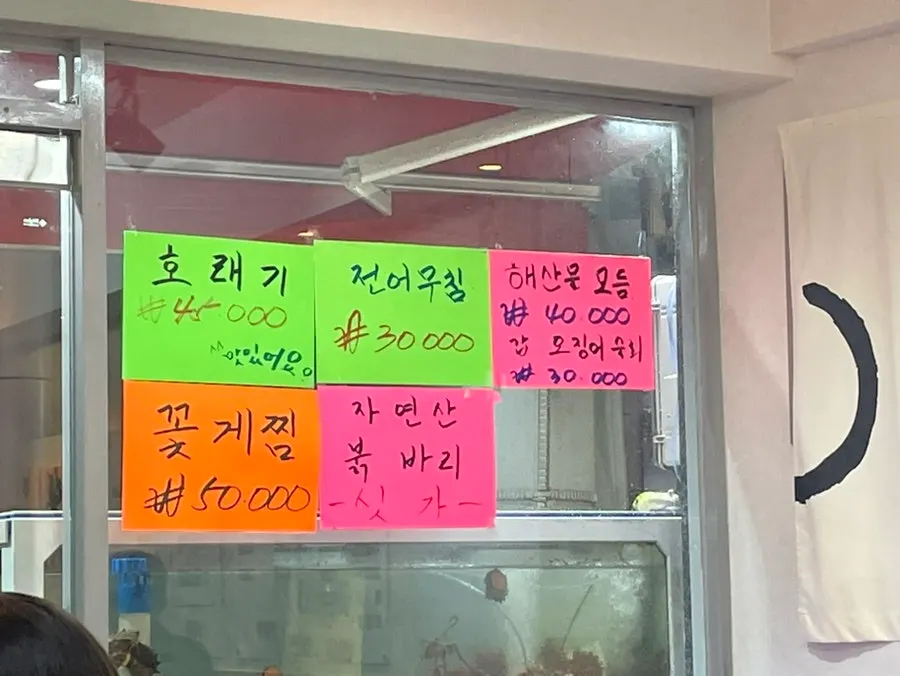 Sign listing braised monkfish, flounder, and other menu items