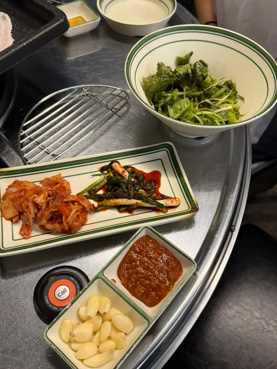Side dish spread including green onion kimchi at Suyeong Naengsam