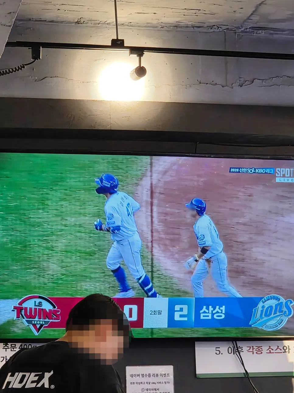 Interior of the restaurant with a large TV showing a baseball broadcast
