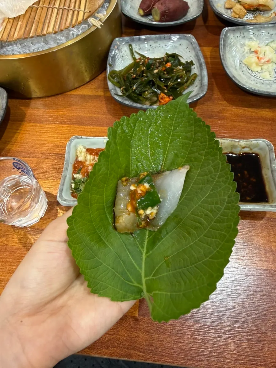A piece of sashimi dipped in wasabi soy sauce
