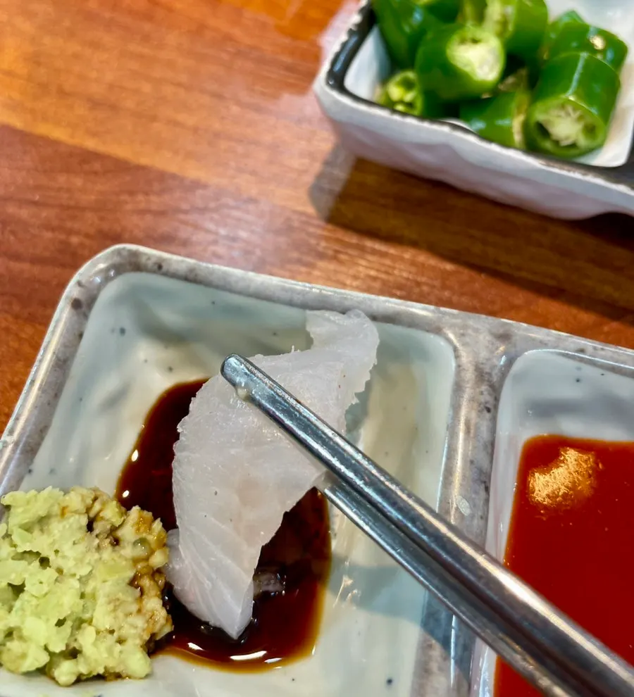 회 한 점을 집어 든 모습