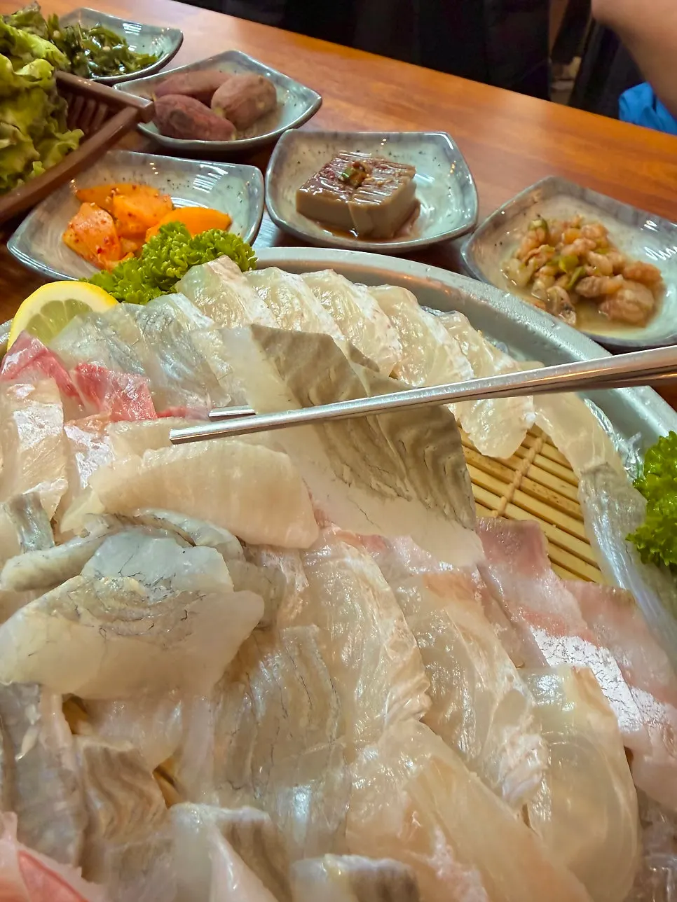 Three pieces of sashimi picked up with chopsticks