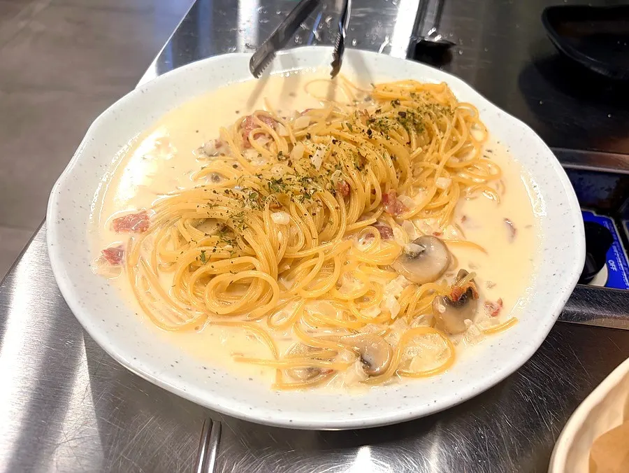 Carbonara topped with bacon and mushrooms