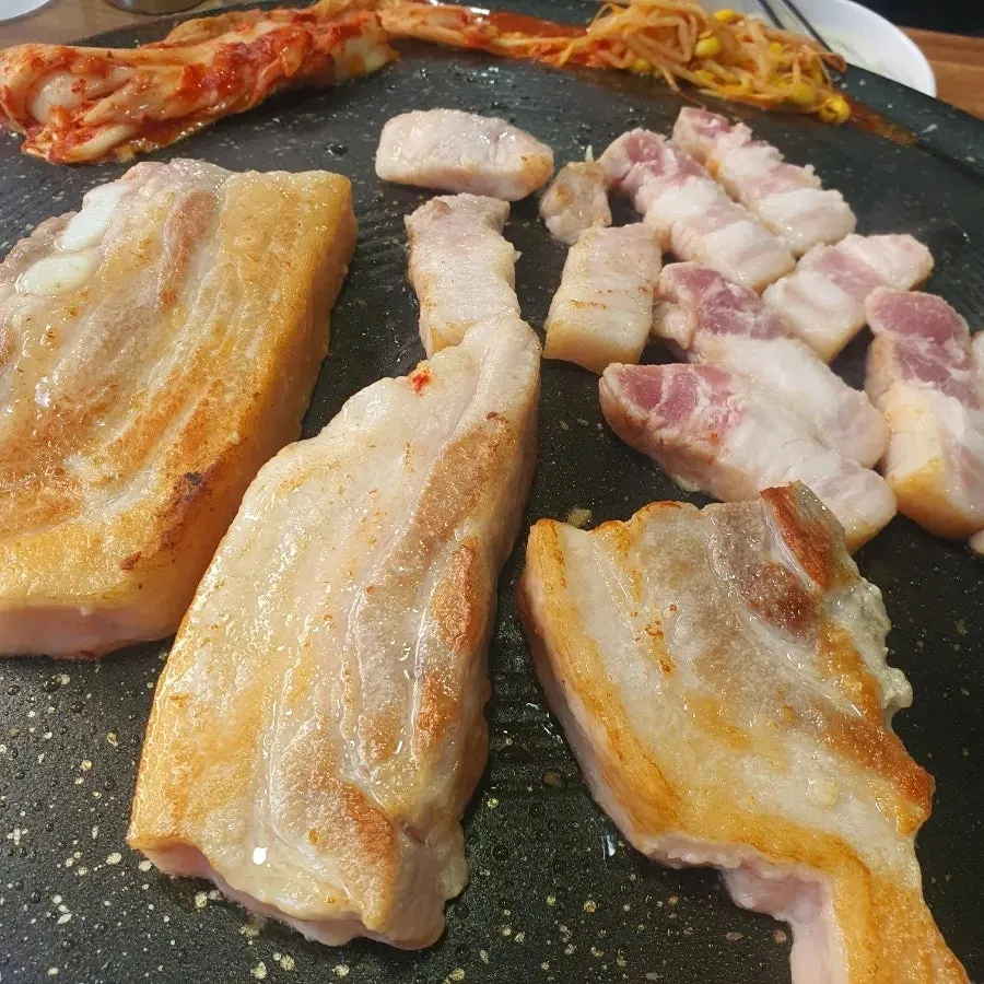 솥뚜껑 불판에서 김치 콩나물과 함께 굽는 통삼겹