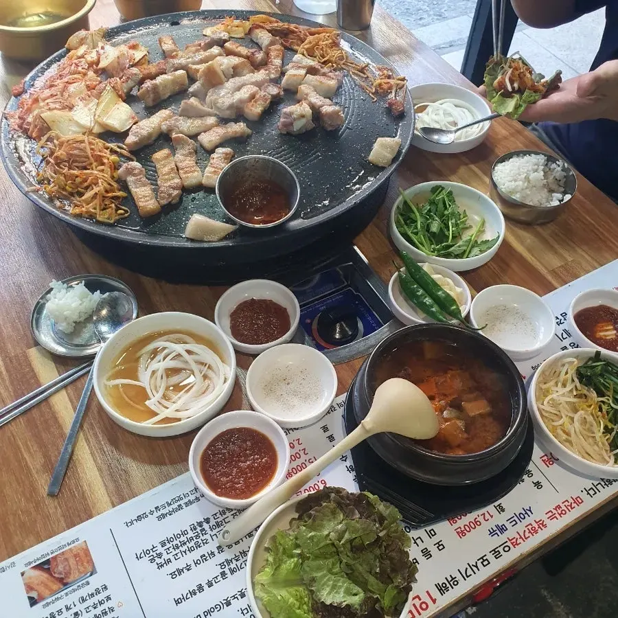 테이블 위 솥뚜껑 불판과 매장 풍경