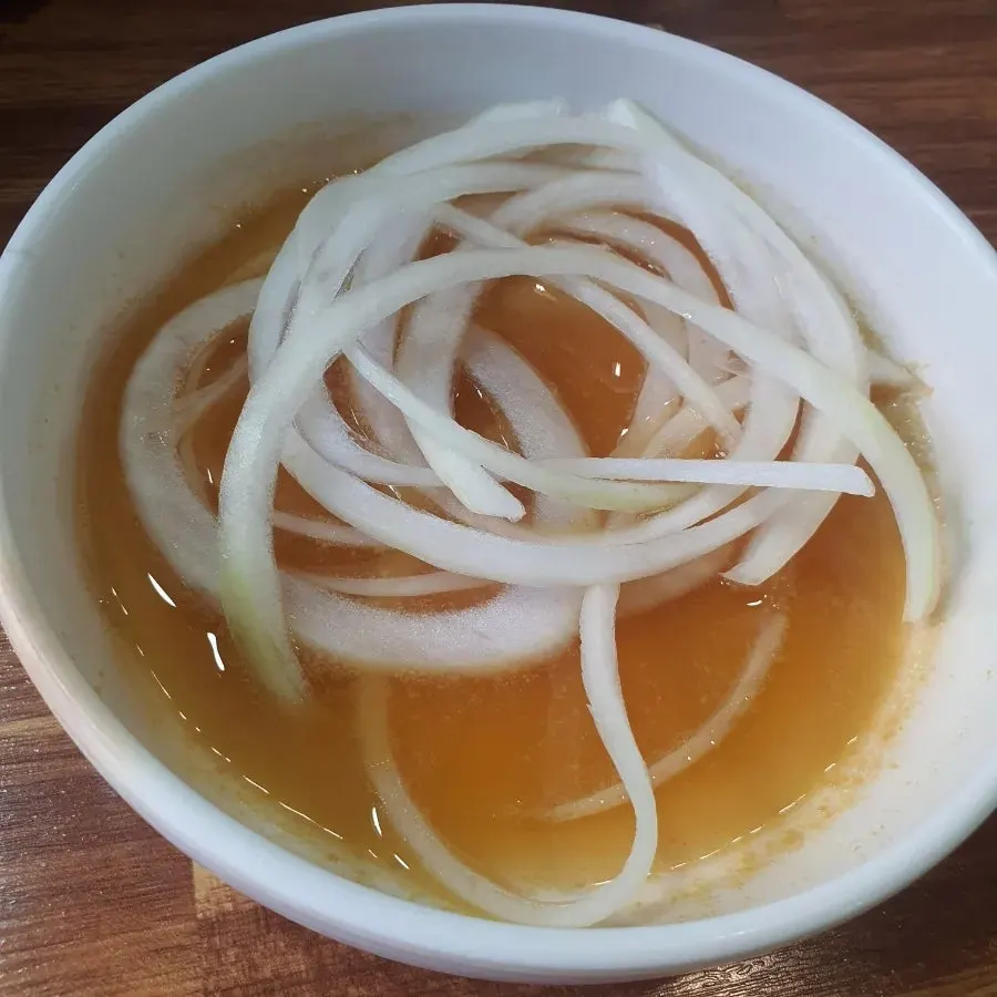 솥뚜껑 가장자리에서 익는 콩나물과 김치