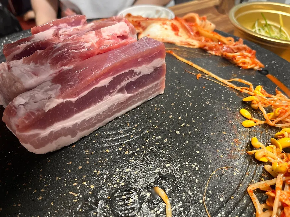 Thick aged whole pork belly placed on the cauldron lid