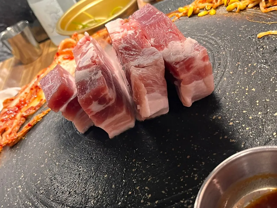 Water dropwort, bean sprouts, and mushrooms arranged around the pork belly