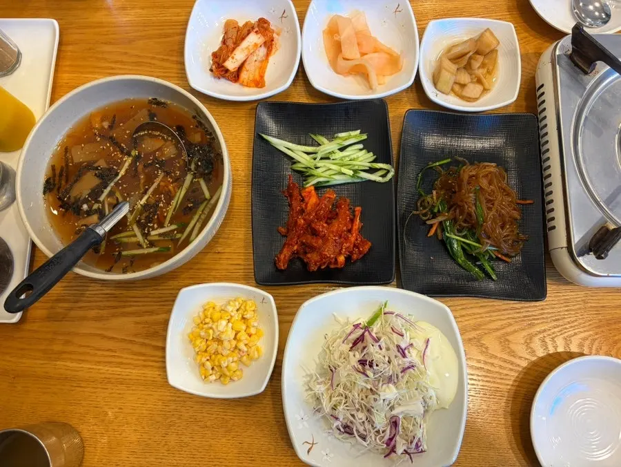 Table spread of side dishes including mook-sabal and japchae