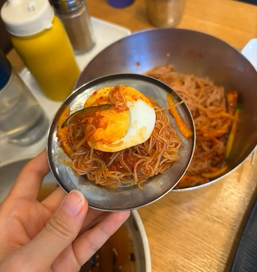 Close-up of hoe-naengmyeon topped with raw fish and sauce